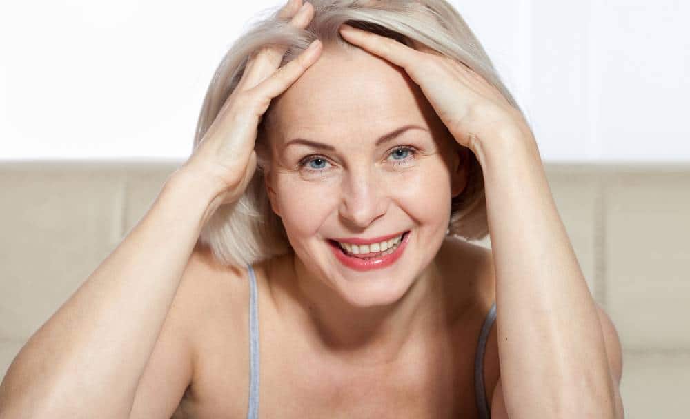 A middle aged woman smiling after her facelift