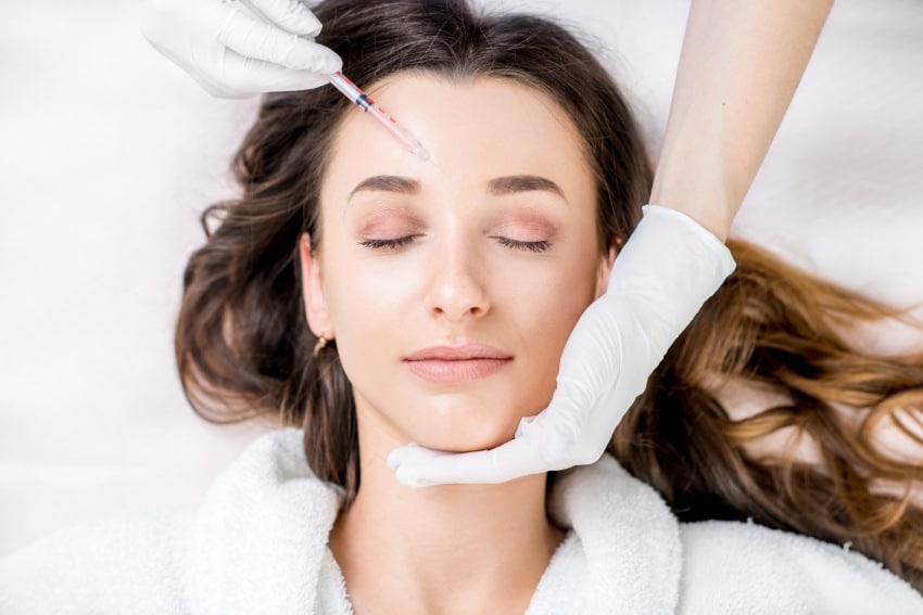 A peaceful woman getting Botox injections above her eyes