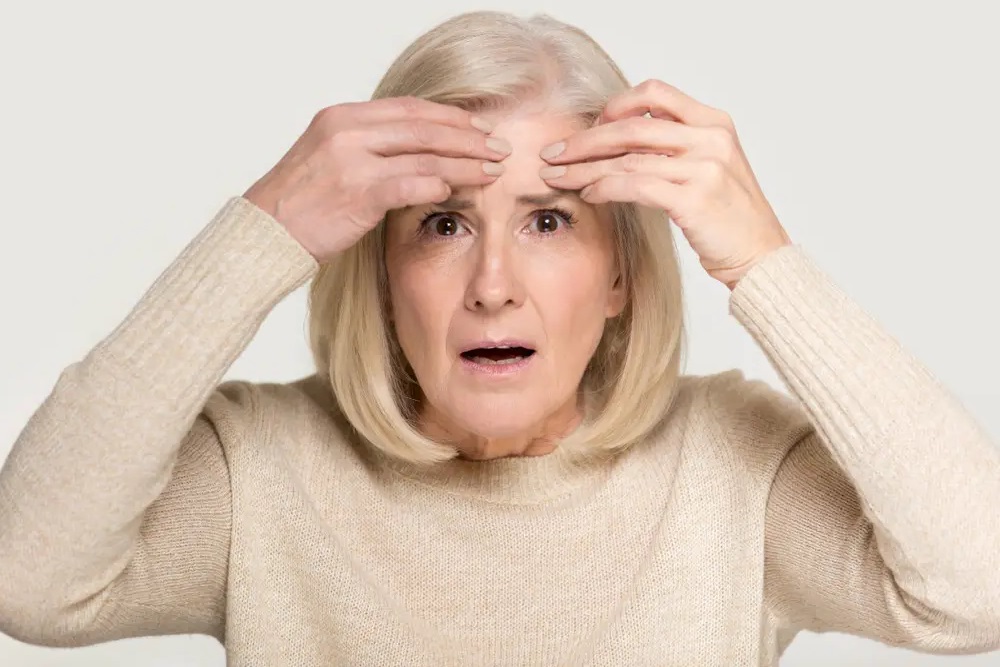 A woman touching her face with a look of dismay