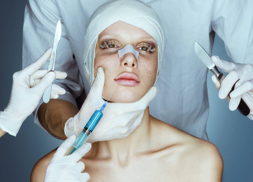 A patient in bandages on her face as she’s undergoing surgery