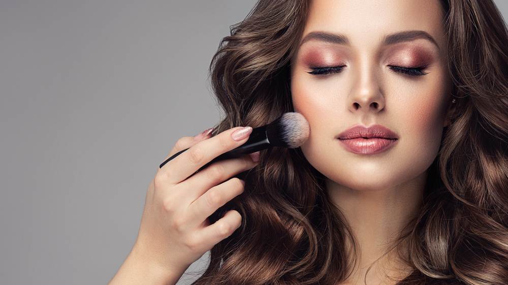 A beautiful woman putting on makeup