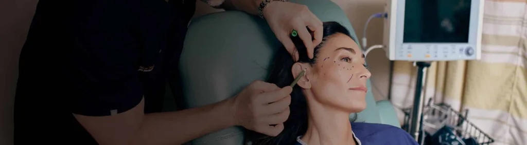 A female patient being marked by surgeon before her facial plastic surgery