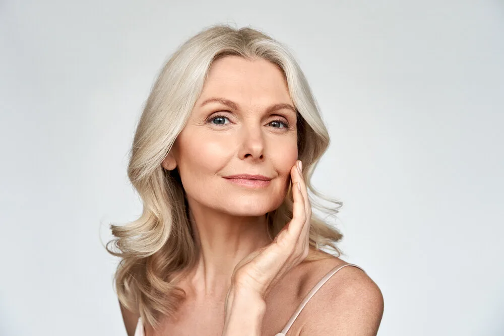 A middle-aged woman touching her face